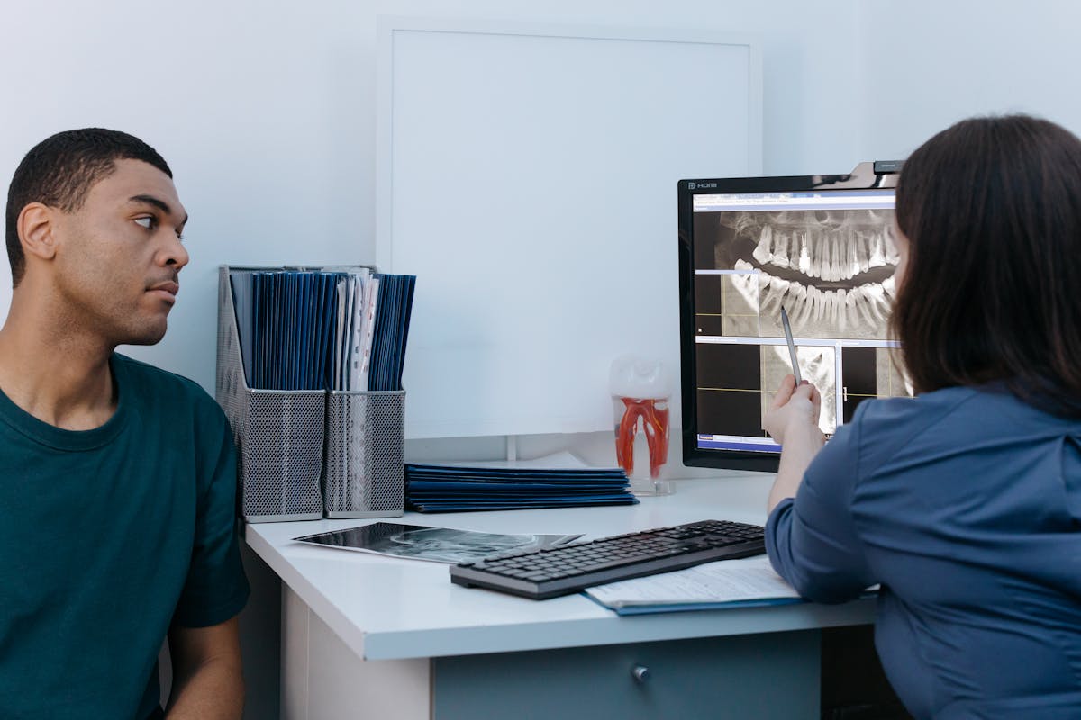 Dentist reviewing digital X-rays with a patient during a consultation